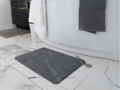 Stone Bath Mat on Tiled Floor outside of bathtub.